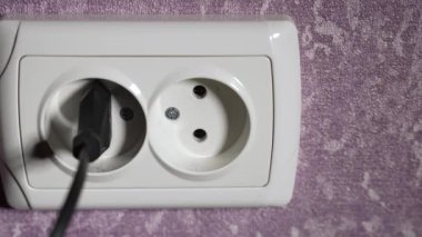 Prizdeki elektrik prizini 220 voltla sökün. Ağır çekim. Dolly vurdu.