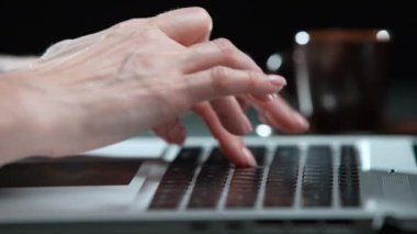 Kadın parmaklar kırmızı zemin üzerinde dizüstü bilgisayara basıyor. Yakın plan.