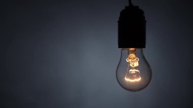 Tungsten spiral parlak lamba siyah arka planda bir kablo üzerinde. Dolly vurdu. Yakın plan.
