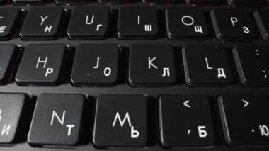 Eski siyah bir dizüstü bilgisayarın klavyesi. Dolly vurdu. Yakın plan.