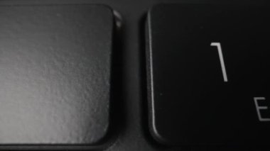 Eski siyah bir dizüstü bilgisayarın klavyesi. Dolly vurdu. Yakın plan.