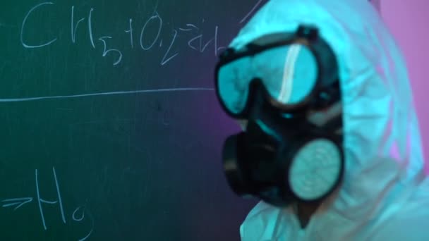 Een Chemicus Een Beschermend Pak Schrijft Een Formule Een Schoolbord — Stockvideo