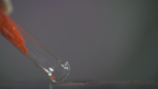 Μια Πορτοκαλί Κρυσταλλική Σκόνη Κρέμεται Από Ένα Δοκιμαστικό Σωλήνα Ένα — Αρχείο Βίντεο