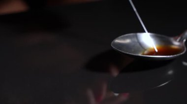 Yemek kaşığından şırıngayı yakın plan çekiyorlar. Yavaş çekim