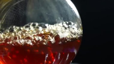 Sıvı, gaz ocağında bir laboratuvar şişesinde kaynıyor. Laboratuvarda uyuşturucu al. Kimyasal reaksiyon. Yavaş çekim