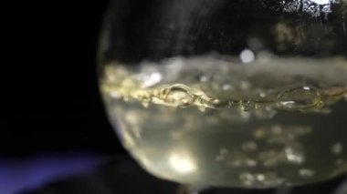 Sıvı, gaz ocağında bir laboratuvar şişesinde kaynıyor. Laboratuvarda uyuşturucu al. Kimyasal reaksiyon. Yavaş çekim