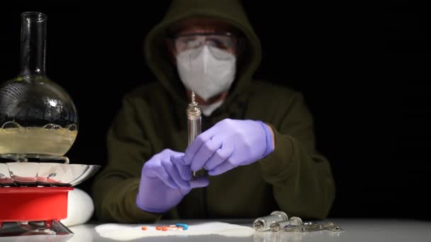 地下化验室的一位化学家在一个气体燃烧器上的玻璃瓶里烹调一种药物 — 图库视频影像