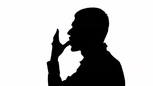 一个人在白色背景下用手舔手指的黑色轮廓 黑色和白色面具 — 图库视频影像