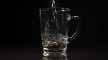 Kaynar suyu siyah çayla birlikte cam bardağa dök. Yavaş çekim