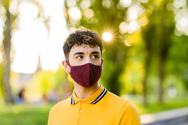 stock image millennial hispanic adult man with face mask for covid-19 protection. health care and medicine