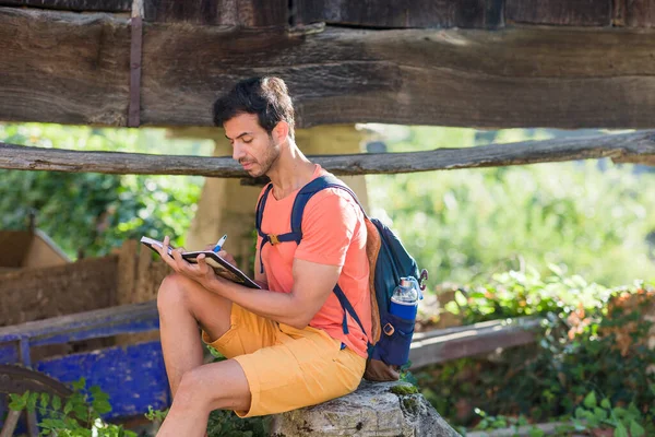 在卡达韦多阿斯图里亚斯 南亚中年背包客男人坐在记事本上 带着笔记本旅游的户外成人肖像画 — 图库照片