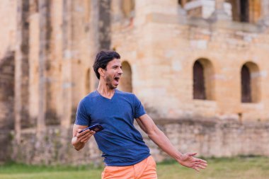 Yakışıklı adamdan gündelik modaya göre Güney Asya kültürü Bollywood dansı. İspanya 'da Asturias unesco anıtı cep telefonuyla mutlu bir şekilde dans ediyor..