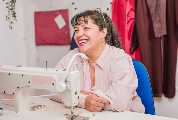 Tekstil endüstrisi profesyonel nakış işi. el işi dikiş makinesi atölyesi. İspanyol iş kadını.