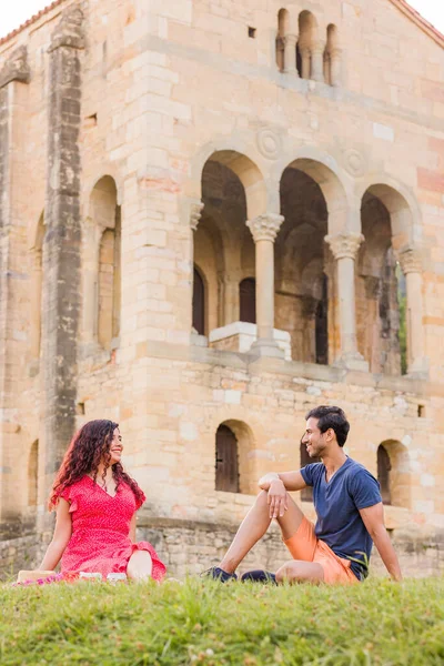 stock image mid adult indian man and latinx woman in front of unesco medieval pre-romanesque historic church. european monument. two people together.