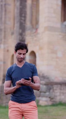 İnternet kullanarak sosyal medya ile modern cep telefonu iletişimi. Açık havada cep telefonu kullanan yetişkin bir turist.