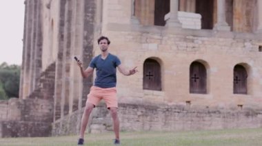 Mutlu Hint etnik köken blogcusu Oviedo İspanya 'daki cep telefonu teknolojisiyle hikayeler kaydediyor. SAnta Maria del Naranco Ortaçağ UNESCO Kilisesi.