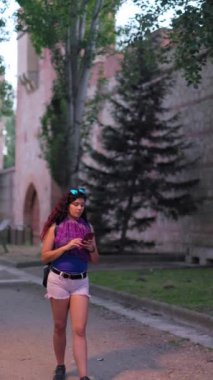 Madrid İspanya seyahati. Orta Latin sırt çantalı kadın sosyal medya blogu için bir aletle yürüyor. Çekim yavaş çekimde dengeleniyor