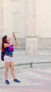 Madrid İspanya seyahati. Orta Latin sırt çantalı kadın sosyal medya blogu için bir aletle yürüyor. Çekim yavaş çekimde dengeleniyor
