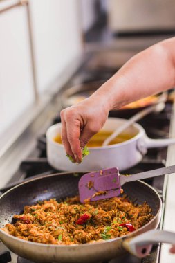 Chef sprinkling fresh cilantro over a flavorful ecuadorian dish in a professional kitchen in madrid, spain, adding the final touch to a traditional recipe clipart