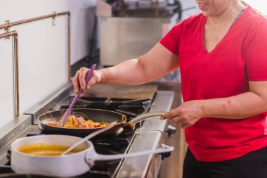 Chef is preparing a traditional ecuadorian dish with shrimps in a professional kitchen located in madrid, spain clipart