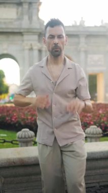 Man dances salsa joyfully in front of the iconic puerta de alcala, a famous landmark in madrid, spain
