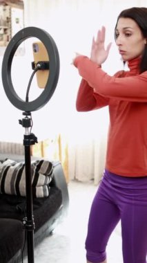 Influencer practicing dance choreography in front of a smartphone, showcasing movements in captivating slow motion