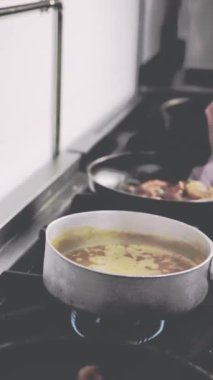 Şef, hareketli bir restoranda geleneksel ekvator yemeği pişiriyor, canlı tatlar ve mutfak teknikleri sergiliyor.