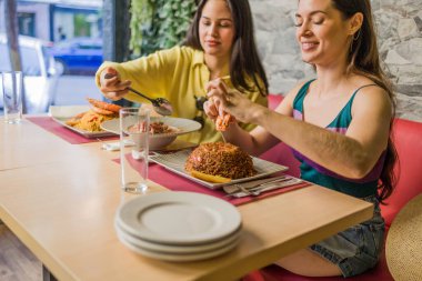 İki kadın Madrid restoranında geleneksel ekvator yemeğinin tadını çıkarıyor, Portoviejo ve Manabi 'nin tadını çıkarıyorlar.