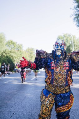 Hispanic dancer wearing traditional clothes dancing during a parade celebrating columbus day or dia de la hispanidad clipart