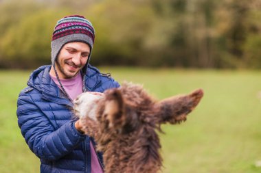 quiros, asturias, spain, çevresel eğitimi ve hayvan bakımını destekleyen bir hayvan barınağında eşeğe sarılmaya gönüllü.
