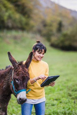 Asterias, İspanya kırsalında eşeğin yanında tablet kullanan işkadını, yenilikçi hayvan bakımı ve çevre eğitimi sunuyor