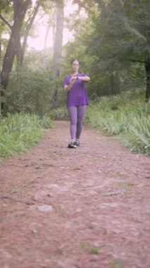 Latin sporcu park yolunda yürüyor, spor yaparken spor performansını ve gelişimi izliyor.