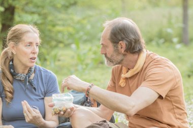 Son sınıf çifti, Madrid, İspanya 'da güzel bir parkta yürüyüş yaparken çerez yiyip dinleniyor.