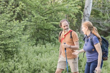 Yaşlı çift Madrid, İspanya 'da yemyeşil bir ormanda yürüyüş yaparak sağlıklı yaşam tarzını ve aktif yaşlanmayı destekliyor.