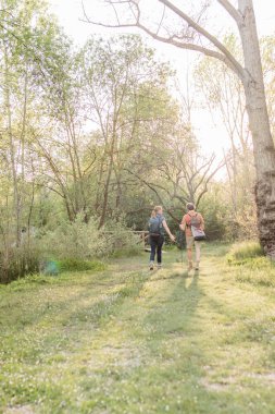 Kıdemli çift Madrid, İspanya yakınlarındaki bir doğa koruma alanında yürüyüş yapıyor. Etrafı yemyeşil yemyeşil ve yaz güneşinin tadını çıkarıyorlar.
