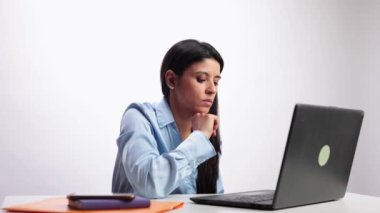 Ofis çalışanı, beyaz arka planda ağır çekimde gösterilen dizüstü bilgisayarı kullanırken boyun rahatsızlığı yaşıyor