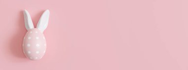 Paskalya yumurtası, tavşan kulağı ve fotokopi alanı olan pembe bir arkaplan. Paskalya arkaplanı. Reklam metni, davetiye, logo için boş yer. Kartpostal, tebrik kartı tasarımı. Pascha, mutlu Paskalyalar. 3 Boyutlu Hazırlama