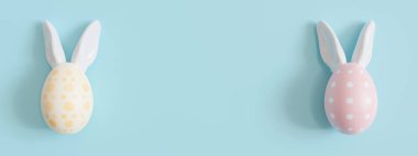 Mavi arka plan, paskalya yumurtaları, tavşan kulakları ve fotokopi alanı. Paskalya arkaplanı. Reklam metni, davetiye, logo için boş yer. Kartpostal, tebrik kartı tasarımı. Pascha, mutlu Paskalyalar. 3 Boyutlu Hazırlama