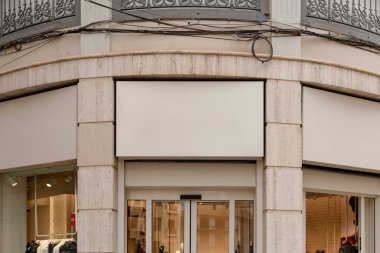 Klasik bir binanın ön cephesinde bir dükkan penceresinin üzerine kurulmuş, metin ya da logo için boş bir yeri olan bir depo önü tabelası. İmza panosu modeli