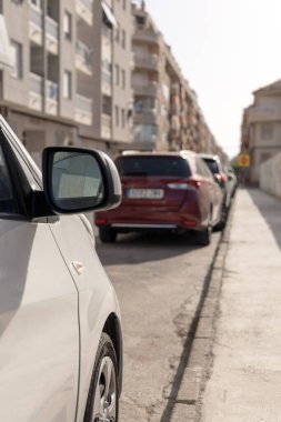 Dar bir şehir caddesi boyunca park halindeki arabalar. Şehir ulaşımı, şehir yaşamı, otomotiv makaleleri veya trafik yönetimi stratejileri için mükemmel bir içerik. Park ücreti. Dikey resim