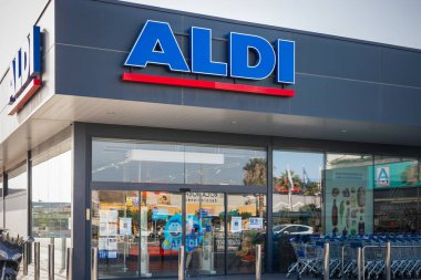 Torrevieja, İspanya - 09-07-2024: ALDI mağazasının dışı. Vitrin önü berrak cam kapılar ve güneşli bir günün arka planına kurulmuş alışveriş arabalarıyla görülebiliyor.