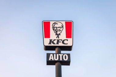 Torrevieja, İspanya - 09-07-2024: ikonik KFC işareti açık mavi gökyüzüne monte edilmiş, tanınabilir logoyu vurguluyor. Kentucky Kızarmış Tavuğu
