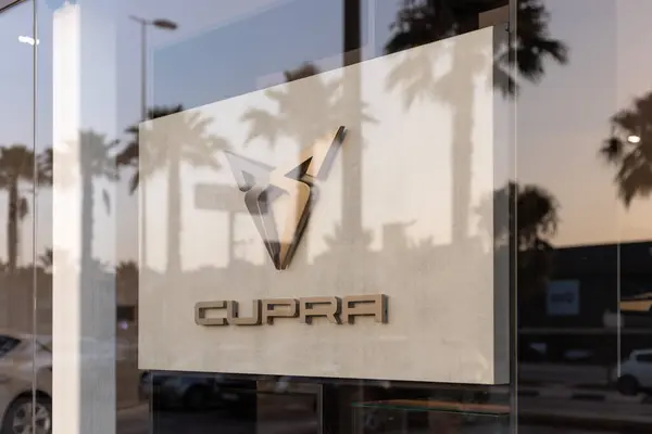 stock image Torrevieja, Spain - 09-07-2024: Cupra logo, highlighted by golden hues of a setting sun. Ideal for automotive branding, marketing materials, and editorial content on modern car brands