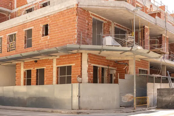 stock image Dynamic process of urban development, showing a partially constructed building with visible brickwork. Ideal for articles on real estate development, urban planning, and construction