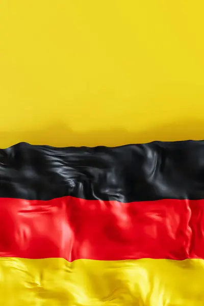 stock image A vivid and flowing representation of the German flag, featuring bold black, red, and yellow colors rippling as if in a gentle breeze. Vertical format. Copy space for text. 3D render