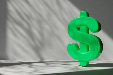 Vibrant green 3D dollar symbol against minimalist gray background with dramatic shadow patterns. Ideal for financial, economic, and eco-friendly business concepts, marketing, and advertising designs clipart