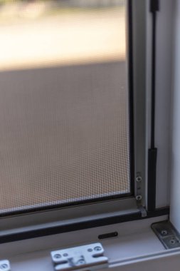 Parlak ışıklandırılmış kapalı alan, etkin sinek koruması için tasarlanmış, titizlikle hazırlanmış bir pencere çerçevesi ve ekranın yakın plan çekimini içeriyor..