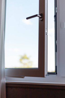 Dışarıdaki ağaçları net bir şekilde görebilmek için güneş ışığının odaya girmesini sağlayan bir pencere açık. Temiz hava boşluğu dolduruyor, atmosferi güçlendiriyor..