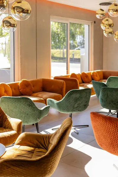 Şık bir lobide, gün boyunca davet edilen yeri aydınlatan altın ışıklı eşyalar ve sıcak renklerde peluş sandalyeler sergilenir..