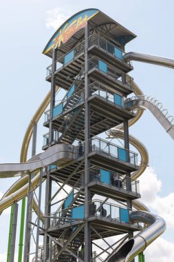 Lichtenau, Almanya - Mai 24, 2025: aileler için tasarlanmış eğlence parkında açık mavi gökyüzüne doğru yükselen kaydırak. Ziyaretçiler güneşli günlerde bu heyecan verici gösterinin keyfini çıkarıyorlar.